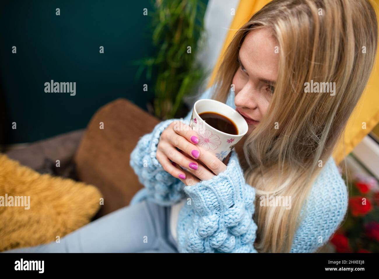 Close-up view of a girl with a mug of coffee in her hands. Stock Photo