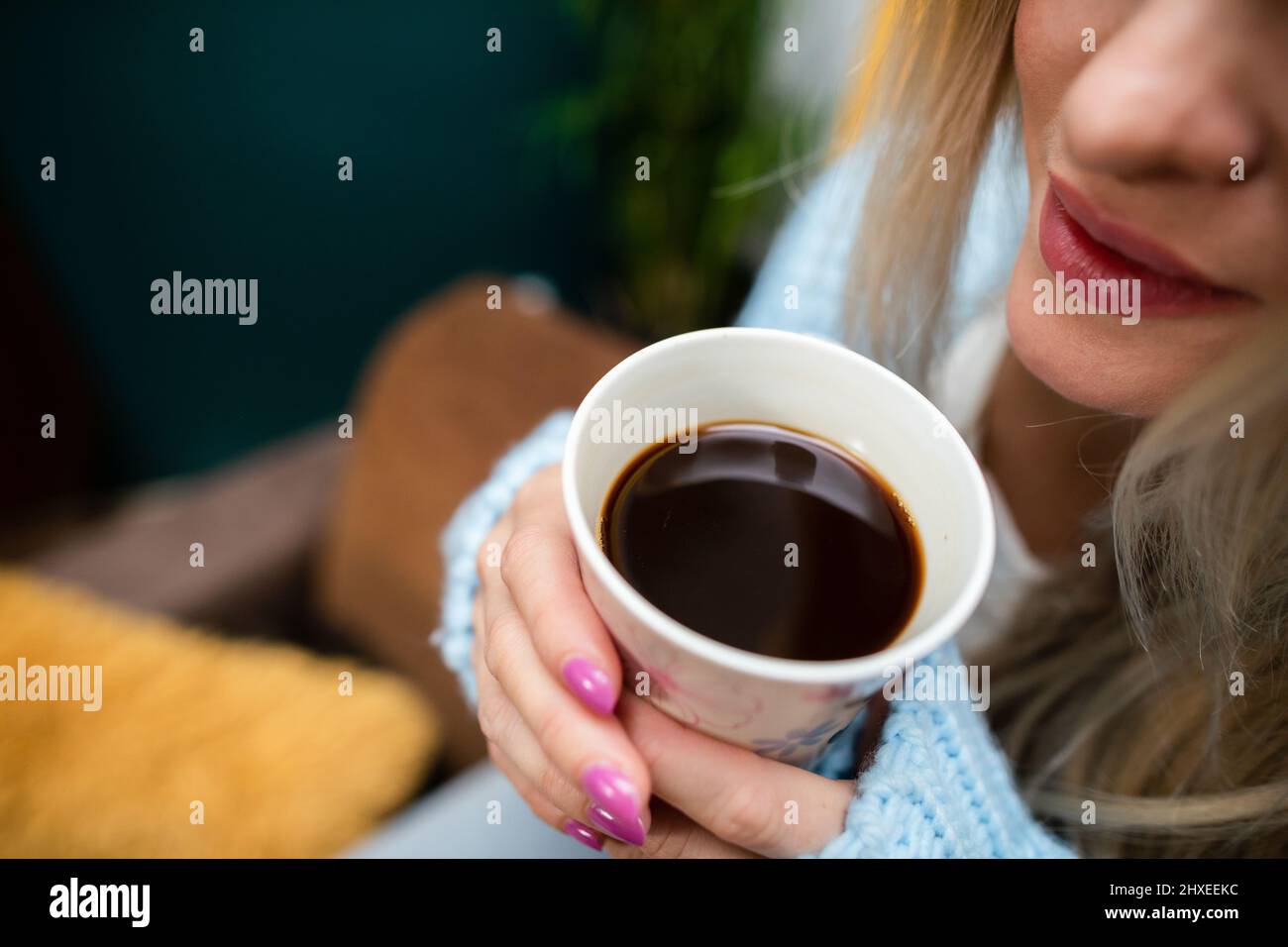 Close-up view of a girl with a mug of coffee in her hands. Stock Photo