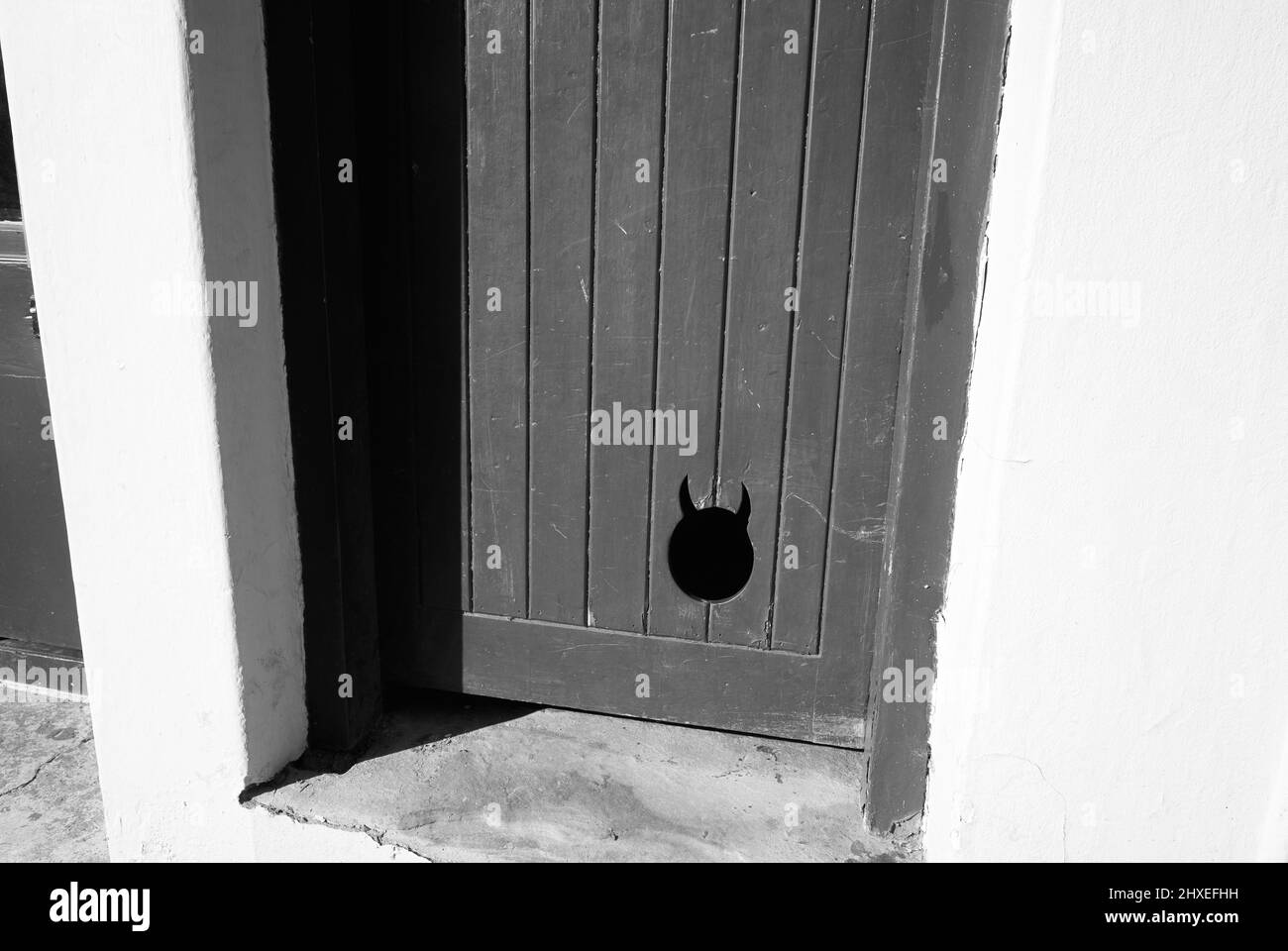 Cat shaped access hole in a wooden door Stock Photo Alamy