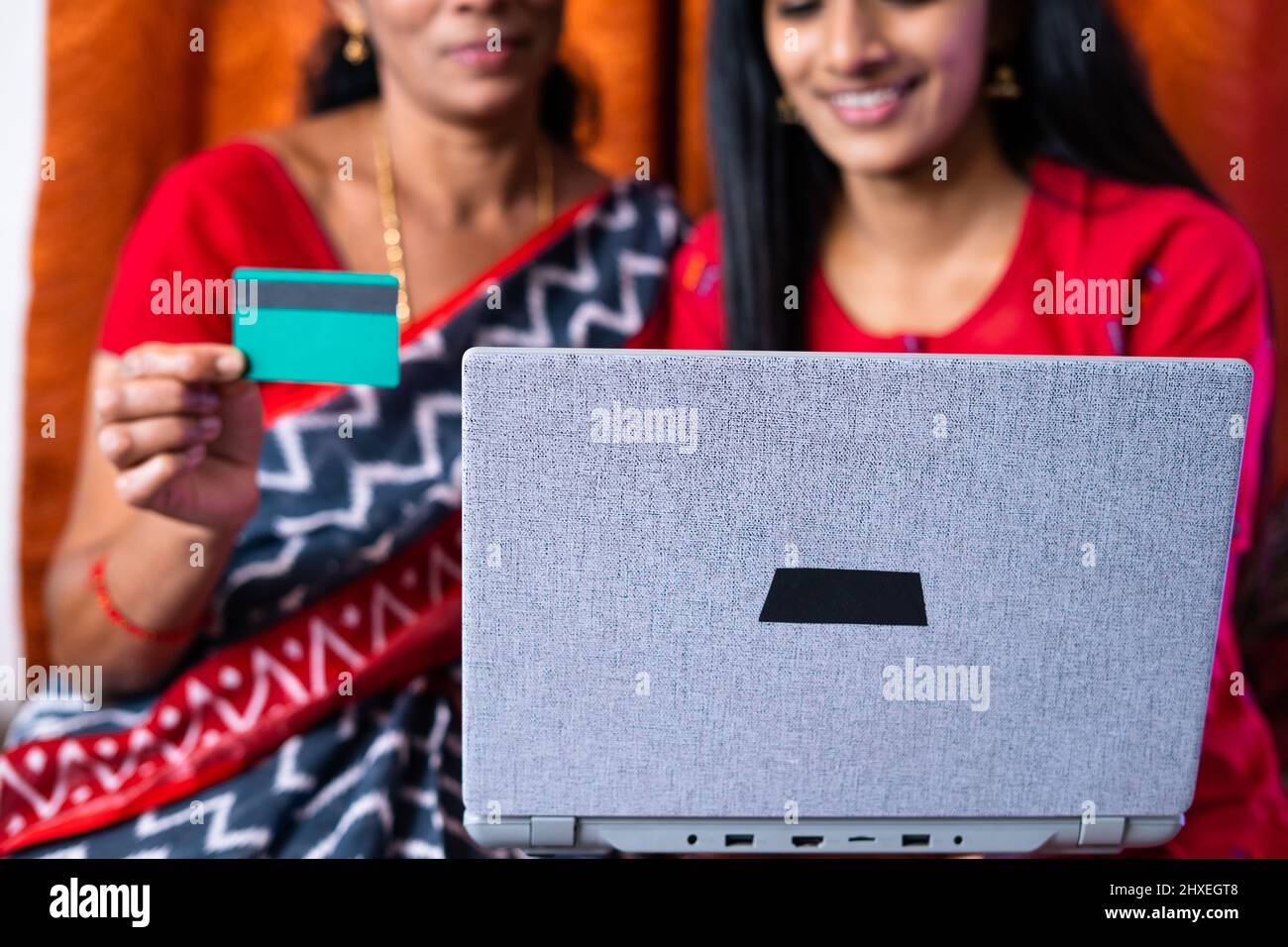 close up shot of mother and daughter making purchases online using credit card on laptop at home - concept of online bill payment and ecommerce Stock Photo
