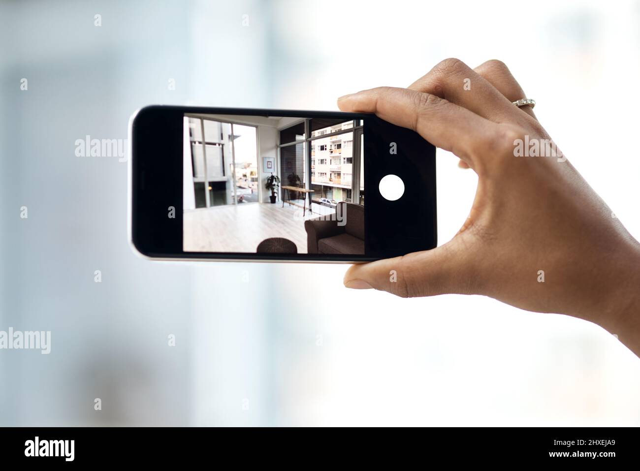 Home viewings gone virtual. Cropped shot of an unrecognisable woman photographing the interior of a house with a smartphone. Stock Photo