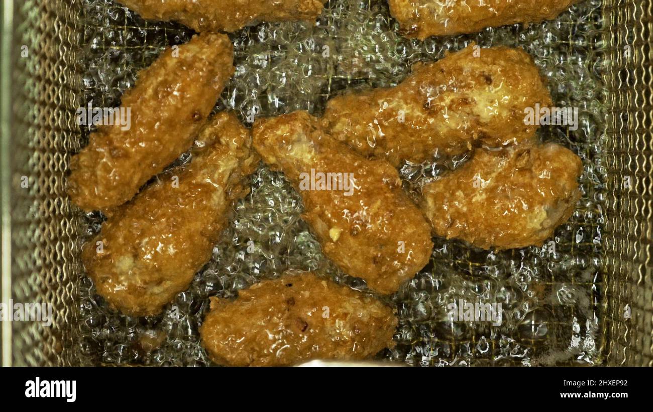 Fast food. Deep fryer with boiling oil and chicken. Large, deeps fryed