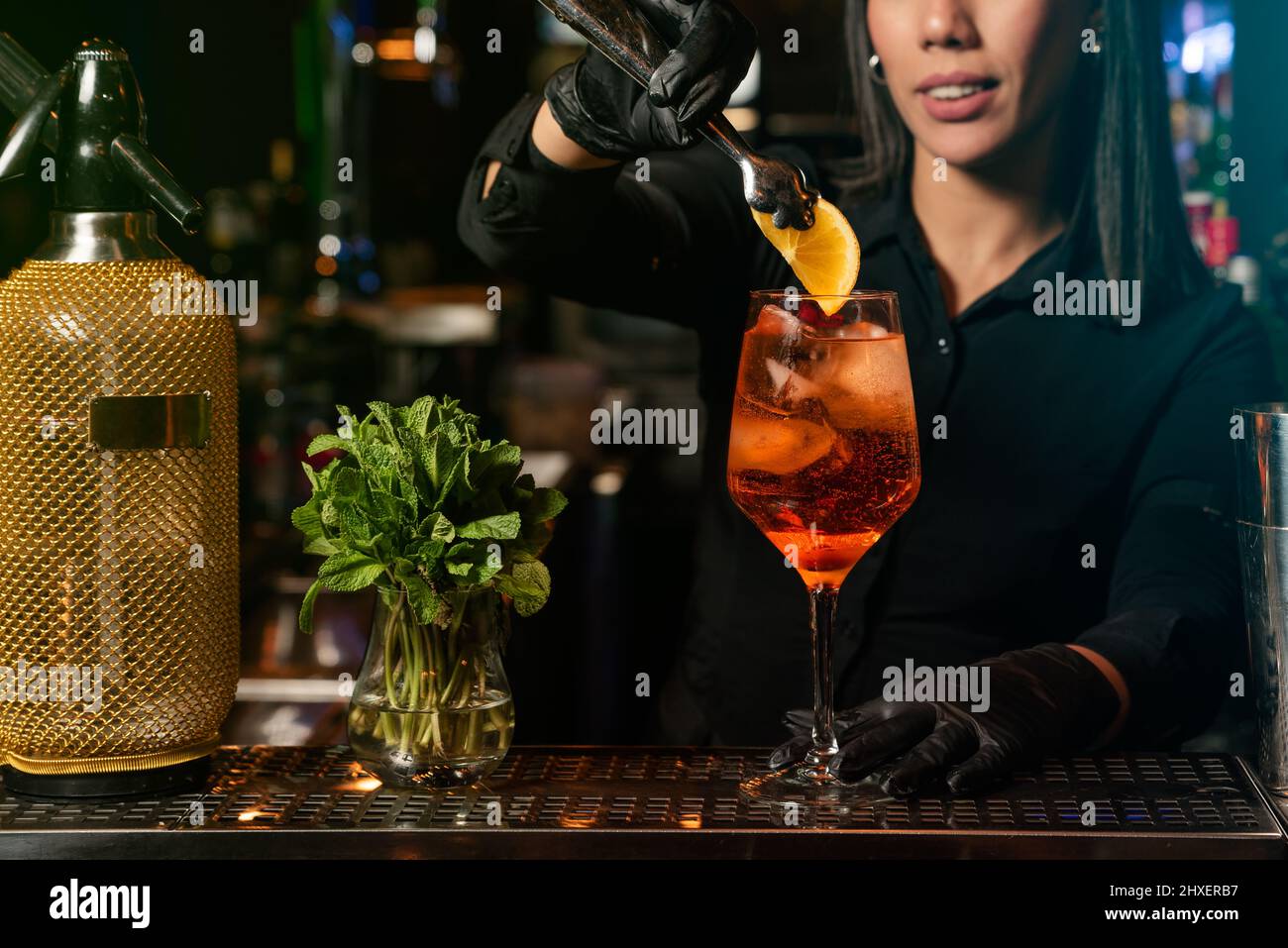 The young Latin prepares a cocktail at the bar counter. job