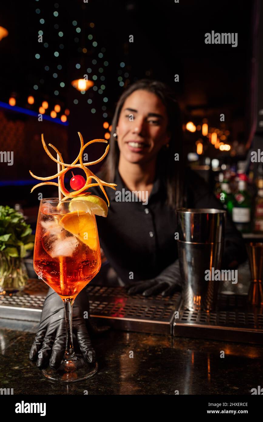 The young Latin prepares a cocktail at the bar counter. job