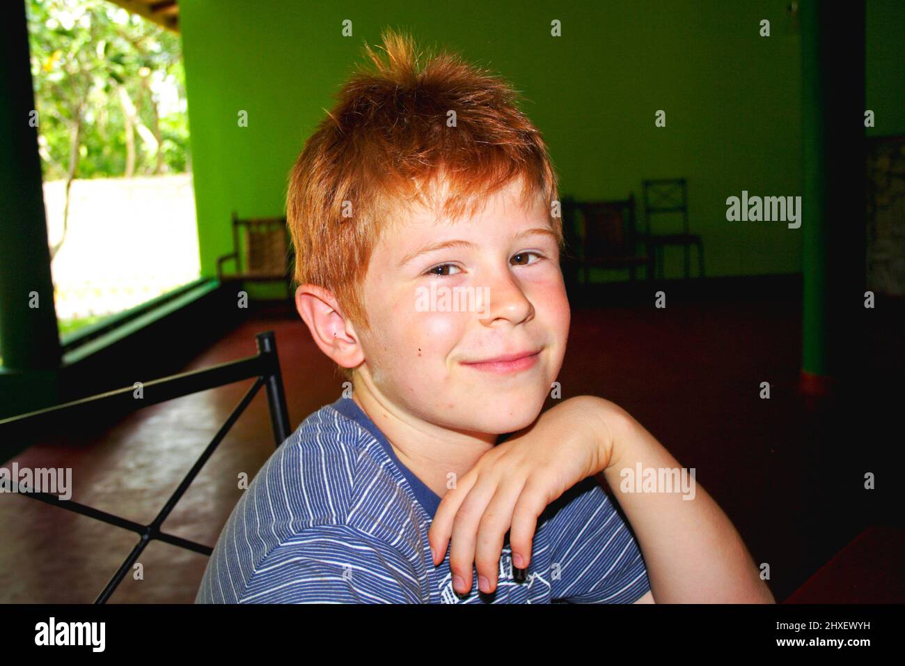 boy sitting un the hotel area enjoys the vacation and smiles Stock Photo