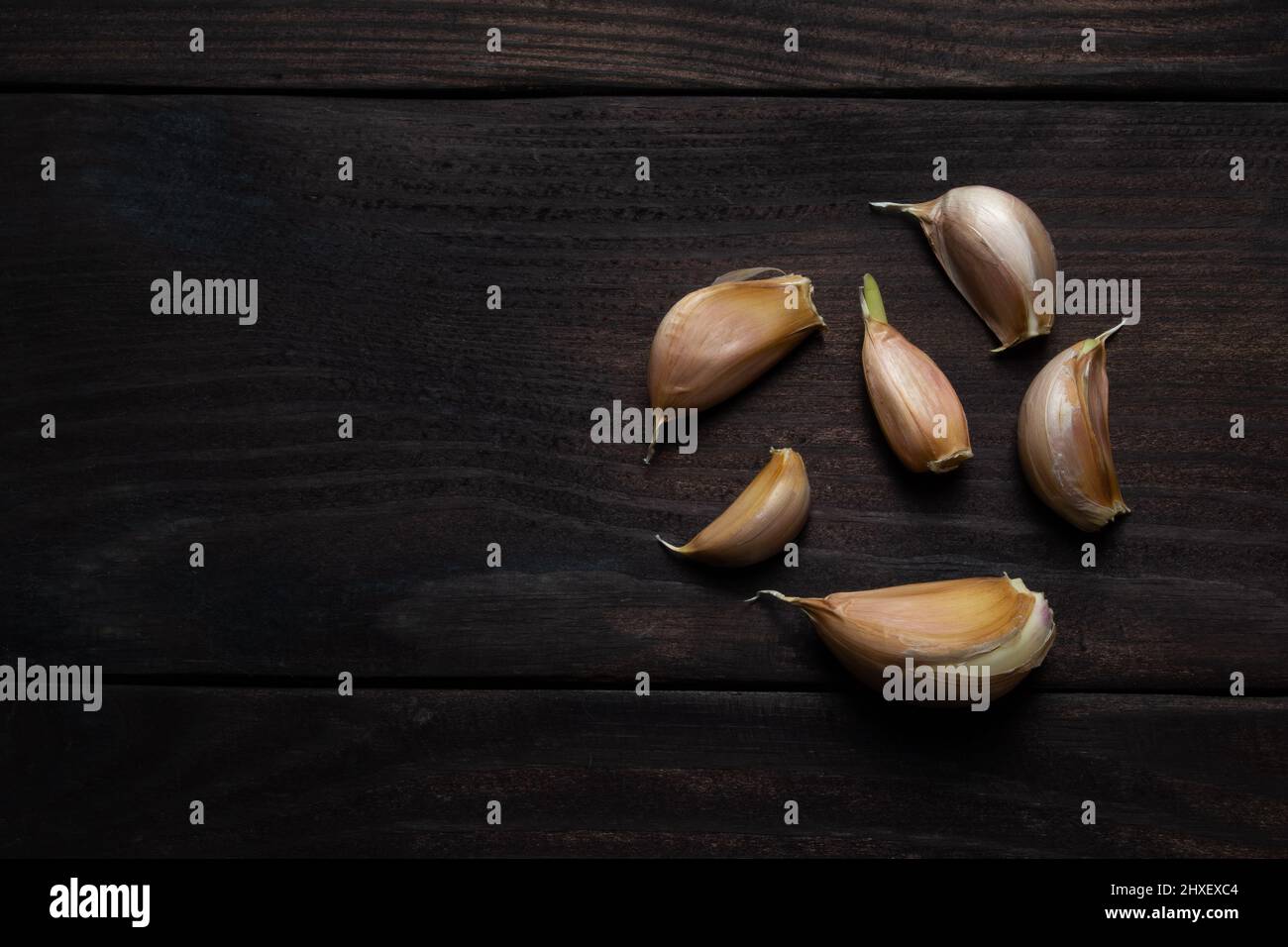 Garlic cloves on dark wood texture. Space for text. Top view Stock ...