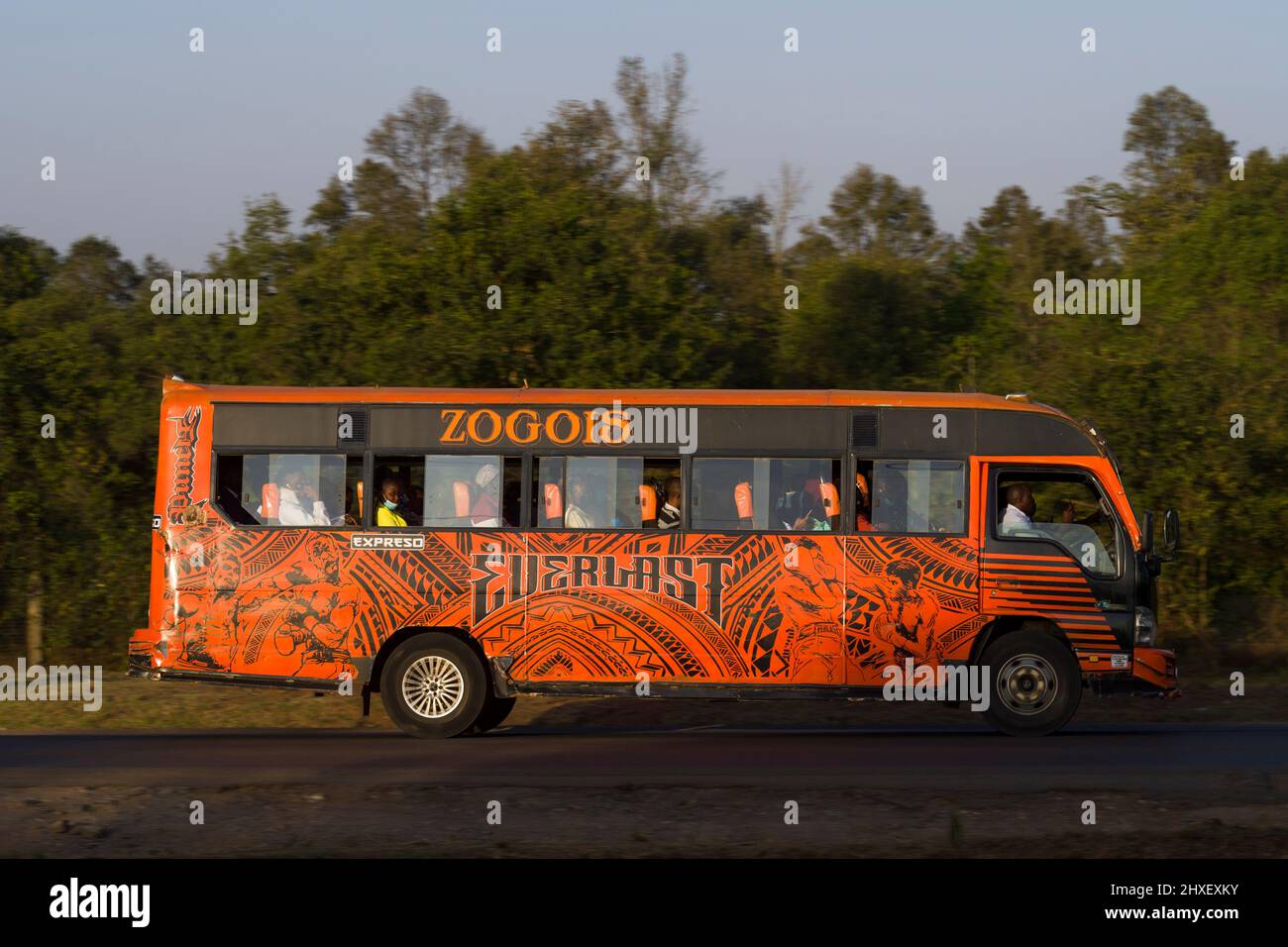 Bus with customised paintwork driving along Magadi Road, Langata. Many buses in Nairobi have custom paintwork, a wide range of subjects are painted, i Stock Photo