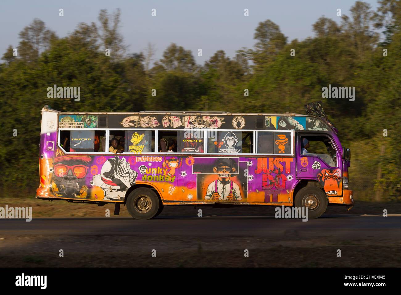 Bus with customised paintwork driving along Magadi Road, Langata. Many ...