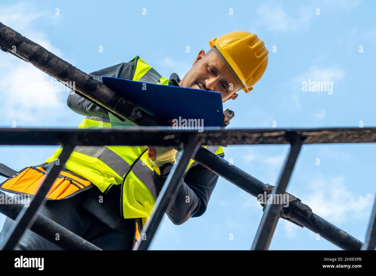 A building foreman taking notes and inspecting the construction work in site. Stock Photo