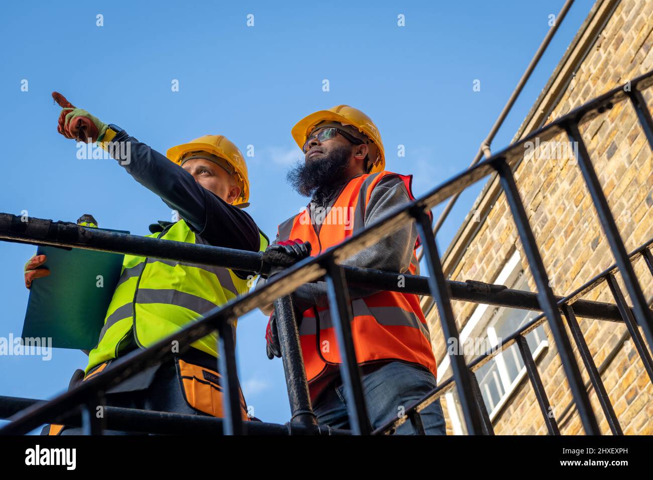 A construction supervisor inspecting the building work with a client. Stock Photo