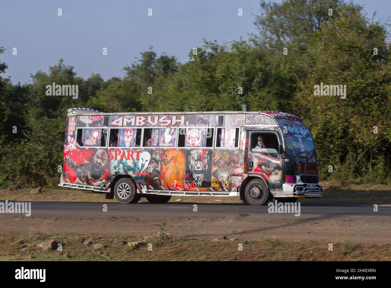 Bus with customised paintwork driving along Magadi Road, Langata. Many ...