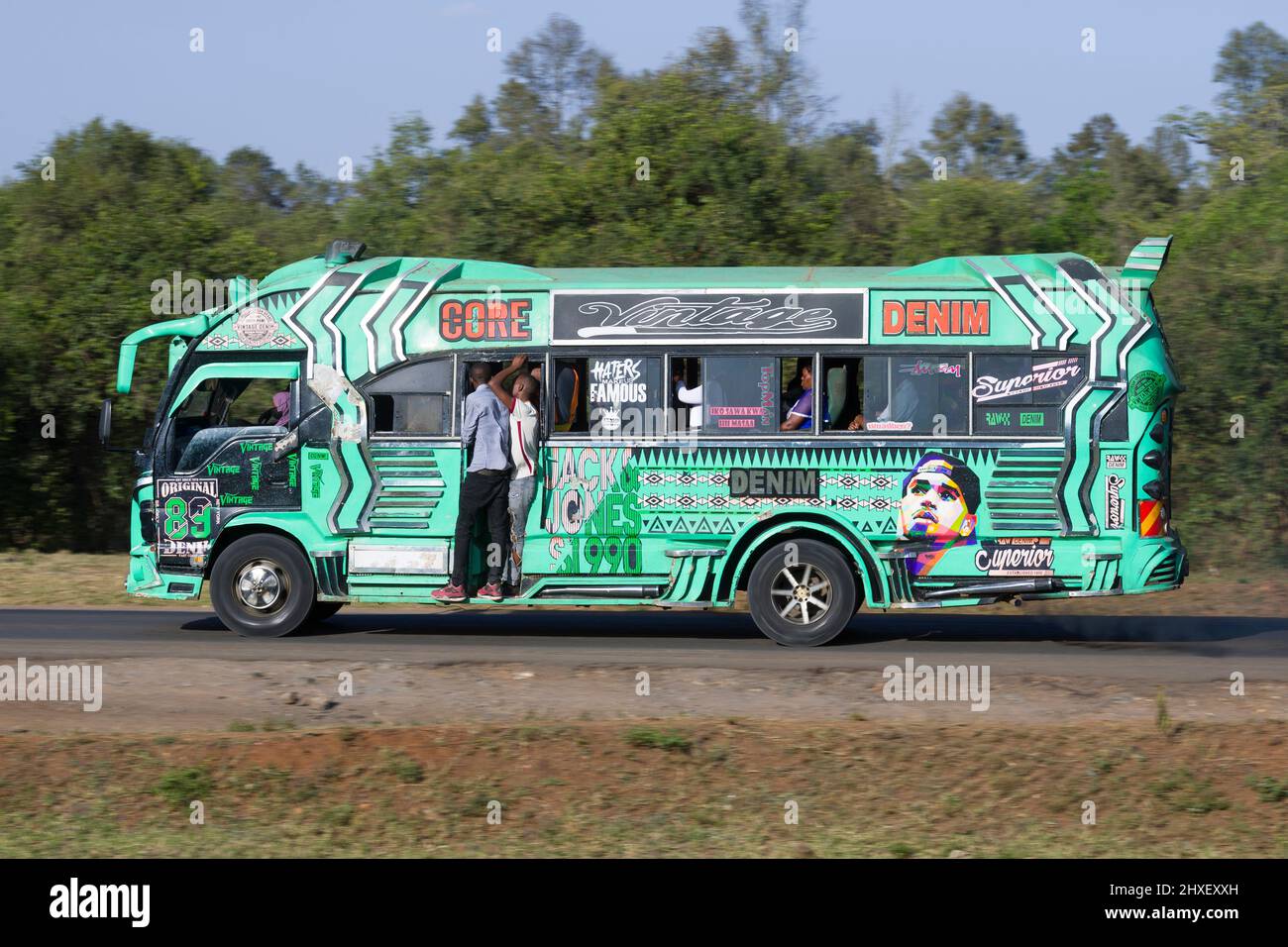 Bus with customised paintwork driving along Magadi Road, Langata. Many buses in Nairobi have custom paintwork, a wide range of subjects are painted, i Stock Photo