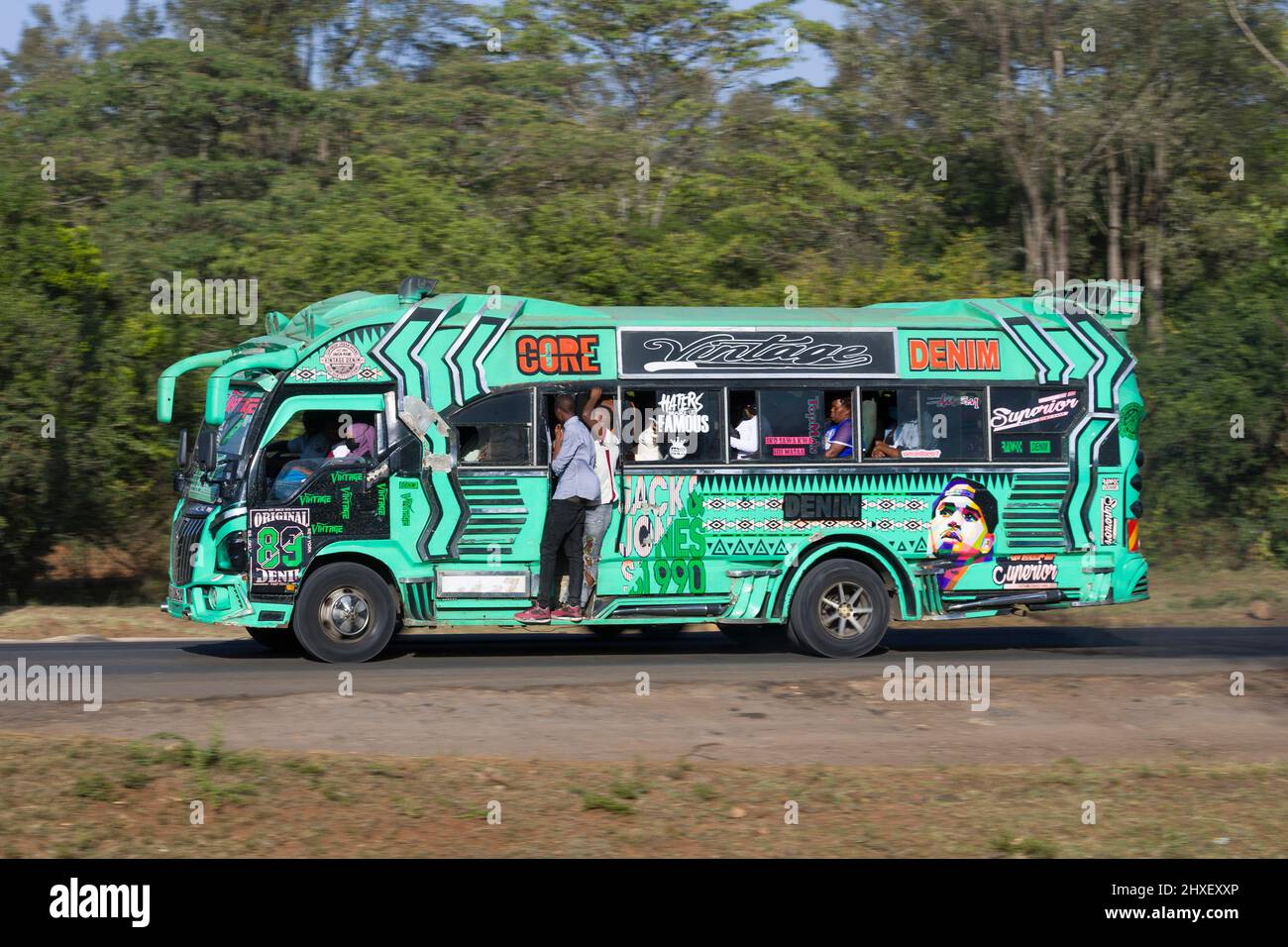 Bus with customised paintwork driving along Magadi Road, Langata. Many buses in Nairobi have custom paintwork, a wide range of subjects are painted, i Stock Photo