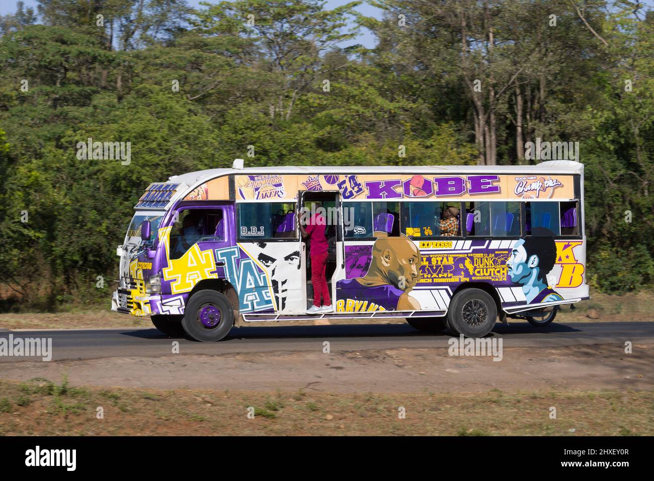 Bus with customised paintwork driving along Magadi Road, Langata. Many buses in Nairobi have