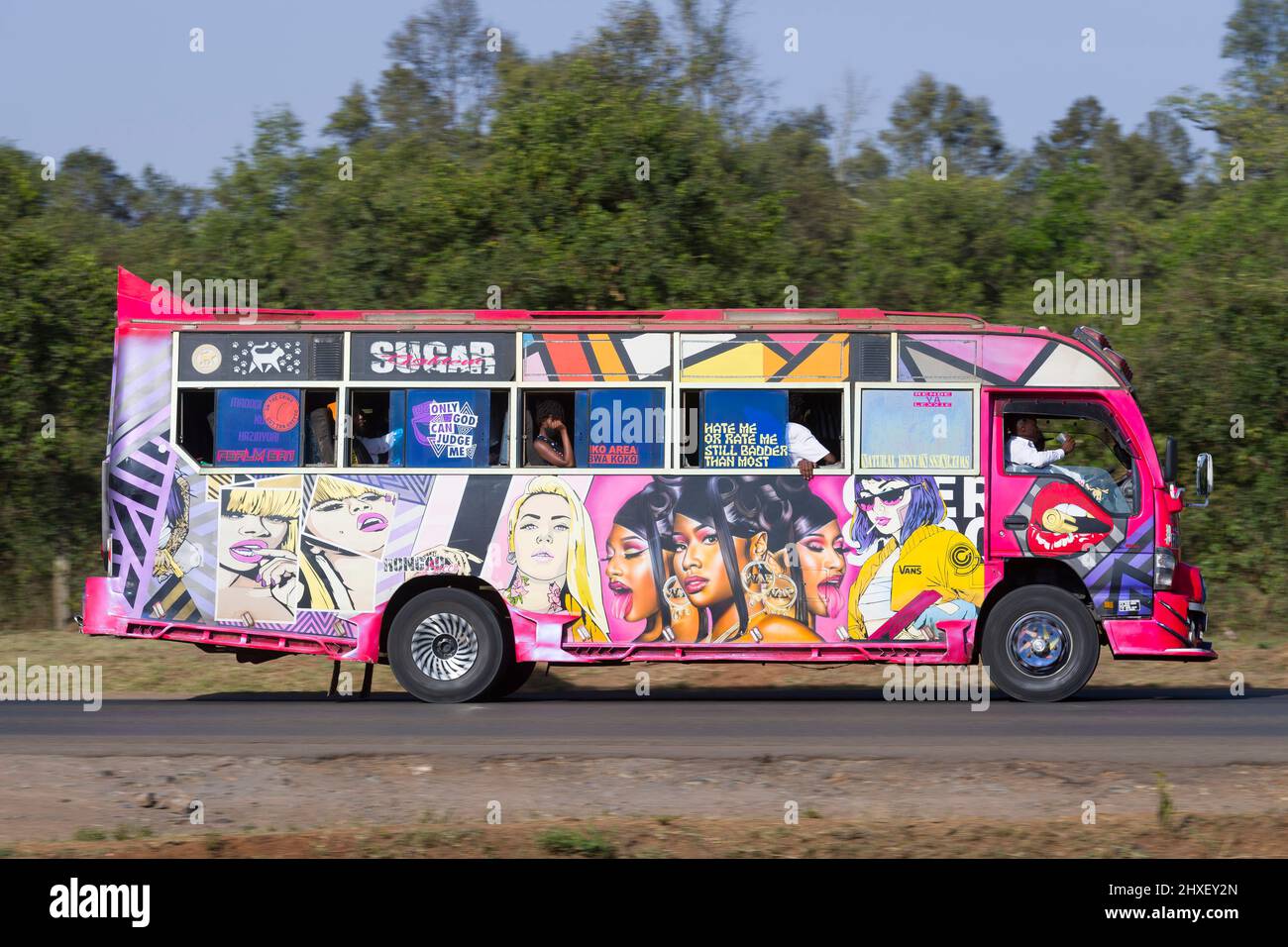 Bus with customised paintwork driving along Magadi Road, Langata. Many ...