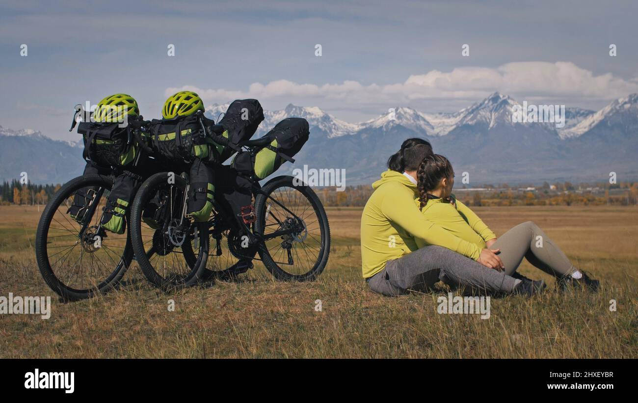 The man and woman travel on mixed terrain cycle touring with bikepacking. The two people journey with bicycle bags. Sport bikepacking, bike, sportswea Stock Photo
