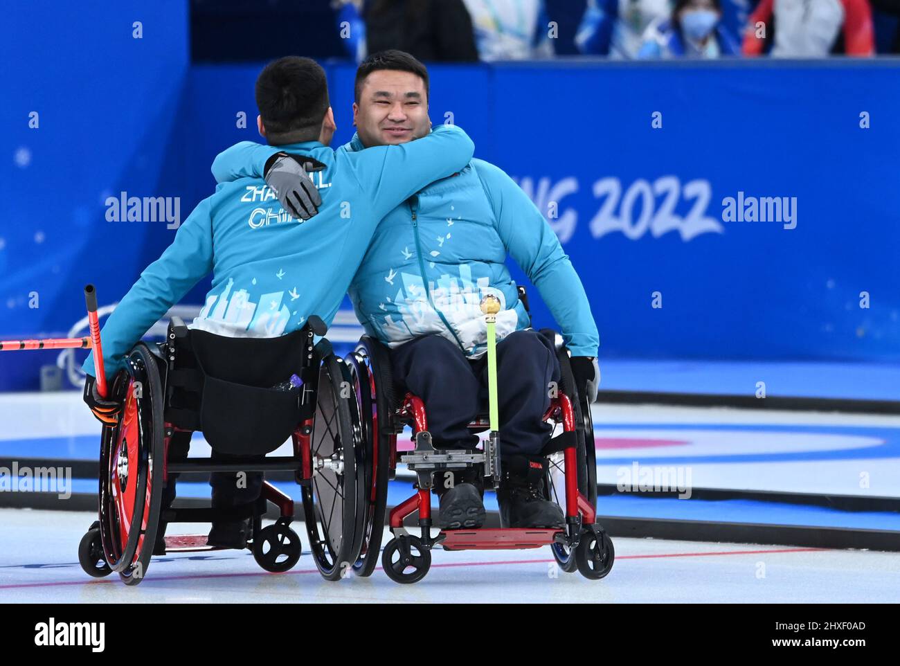 Beijing, China. 12th Mar, 2022. Wang Haitao (R) of China reacts with ...