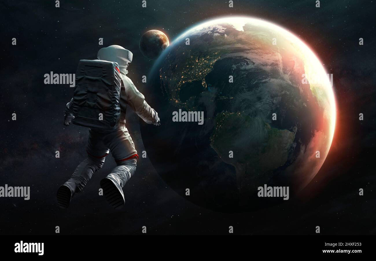 Astronaut at spacewalk looks at Earth planet. Elements of image provided by Nasa Stock Photo