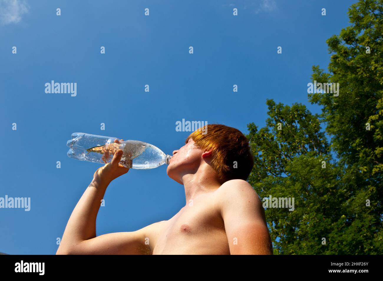 Teen Boy 12-14 Year Old Drinking Fresh Water From A Bottle. Student Teenager  With Headphones And Sunglasses Posing Outdoors. Stock Photo, Picture and  Royalty Free Image. Image 60008603.