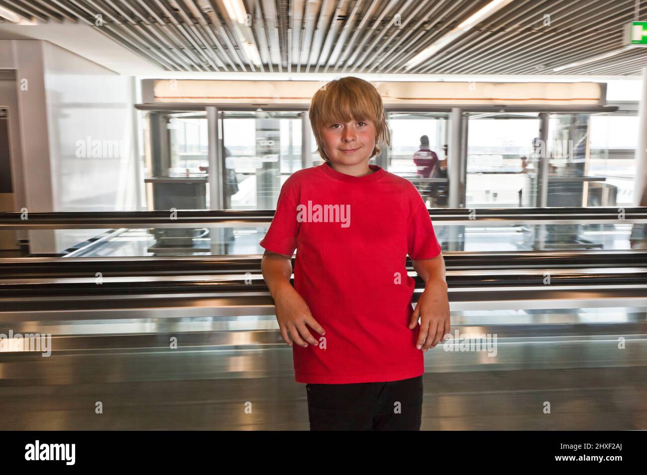 boy on a moving staircase inside the airport Stock Photo