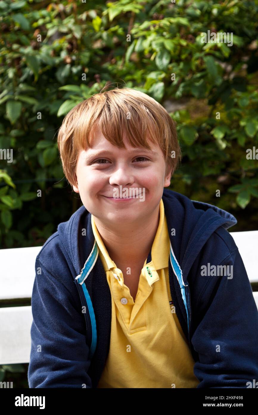 boy sitting on a bench in a park Stock Photo - Alamy