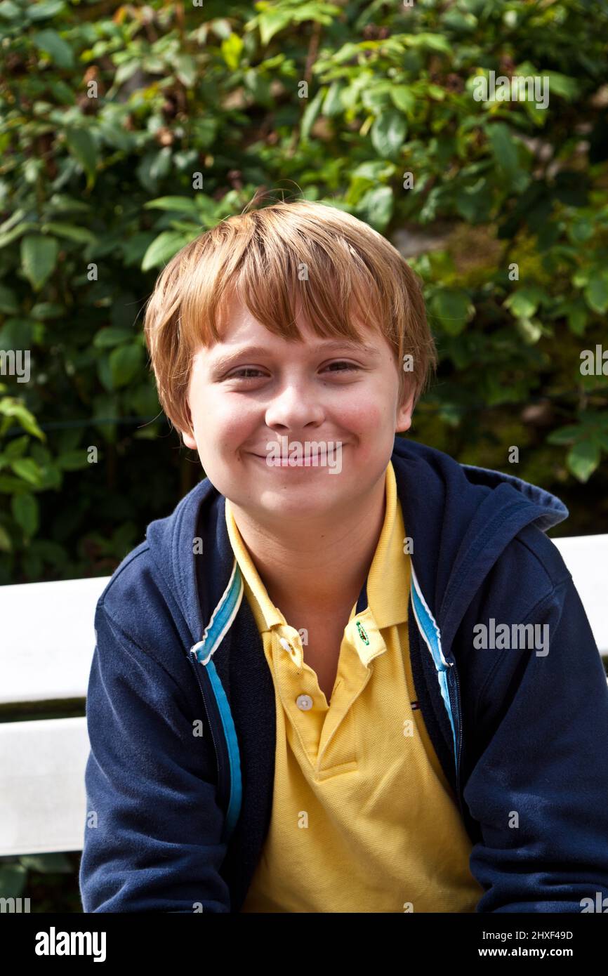 boy sitting on a bench in a park Stock Photo - Alamy