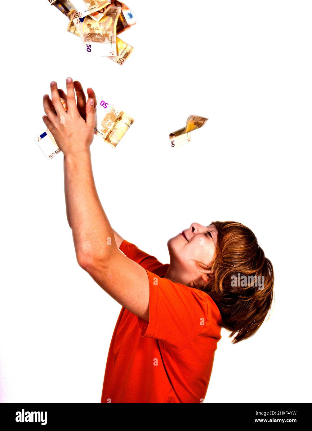 Euros flying around a boys head Stock Photo