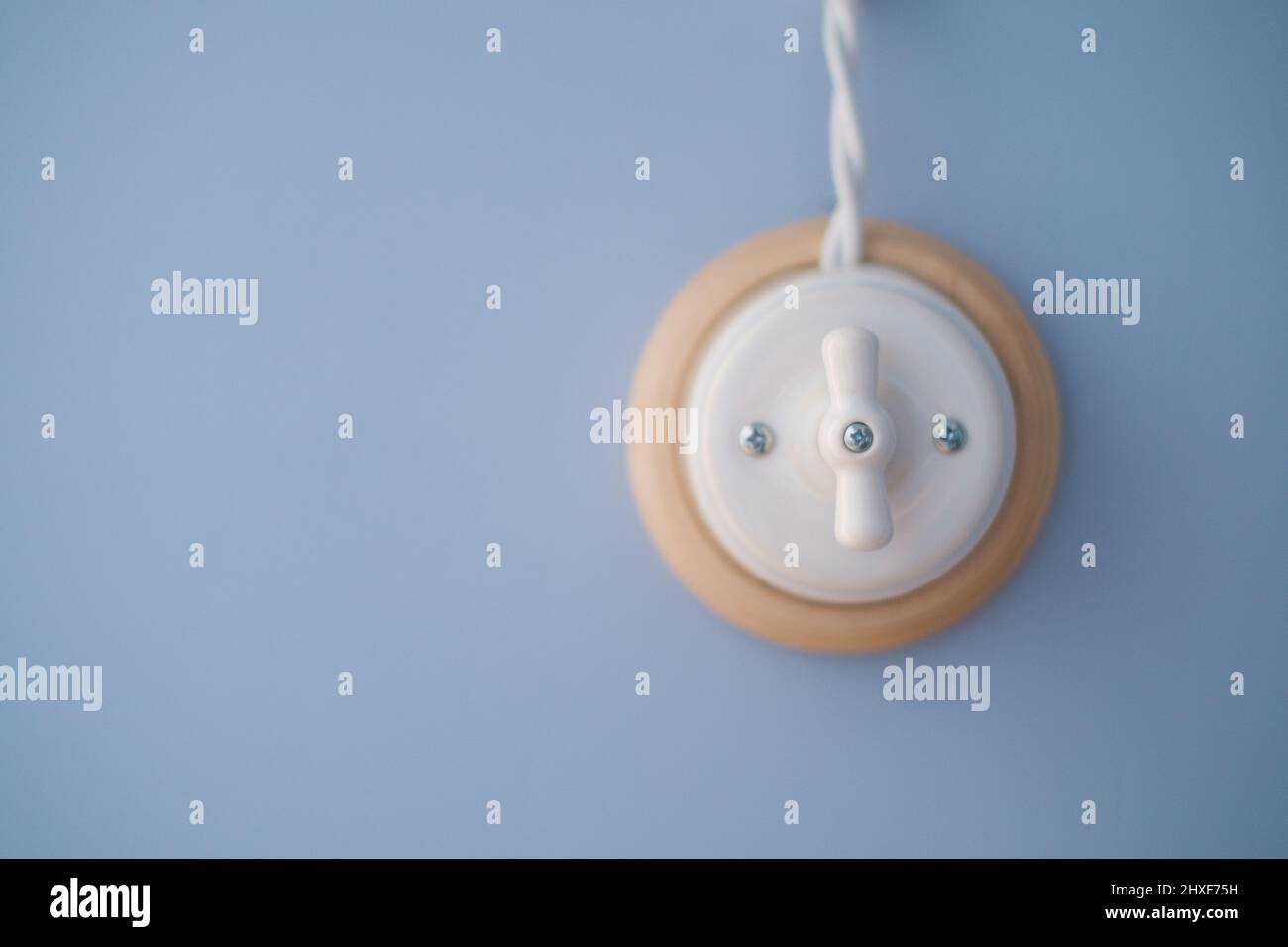 Retro light switch solated on blue background. Stock Photo
