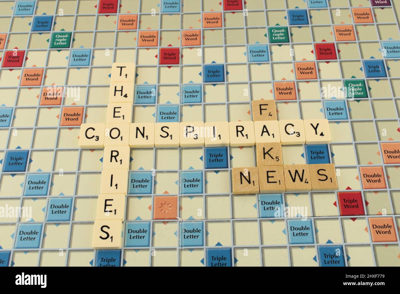 Conspiracy theories and fake news on a scrabble board background. Propaganda concept Stock Photo