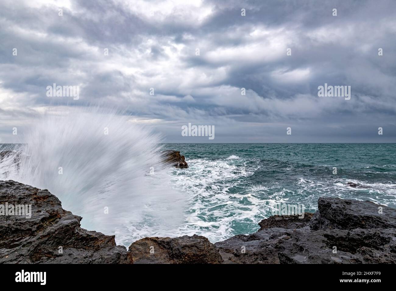 Stunning wave splash at rocky shore and scenic clouds Stock Photo - Alamy