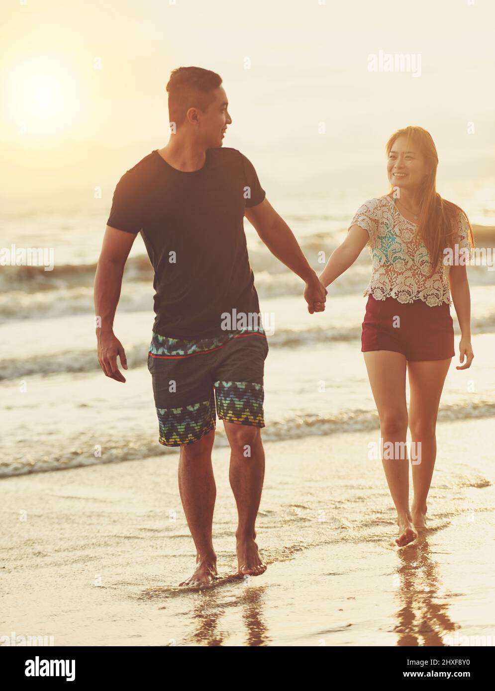 Taking long walks and talking about our future together. Shot of an affectionate couple walking hand in hand on the beach. Stock Photo