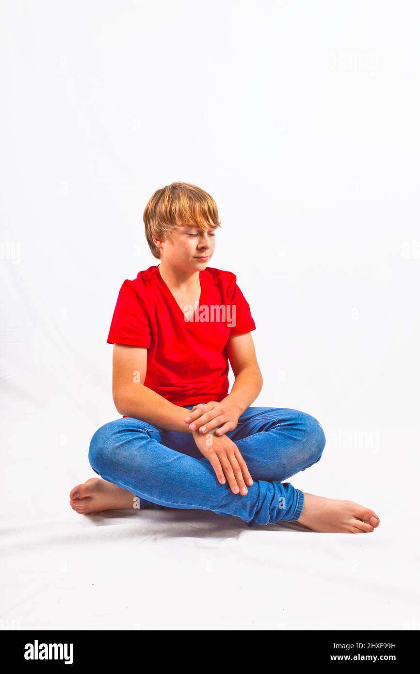 smart boy with red shirt sitting in tailor seat at the floor Stock Photo
