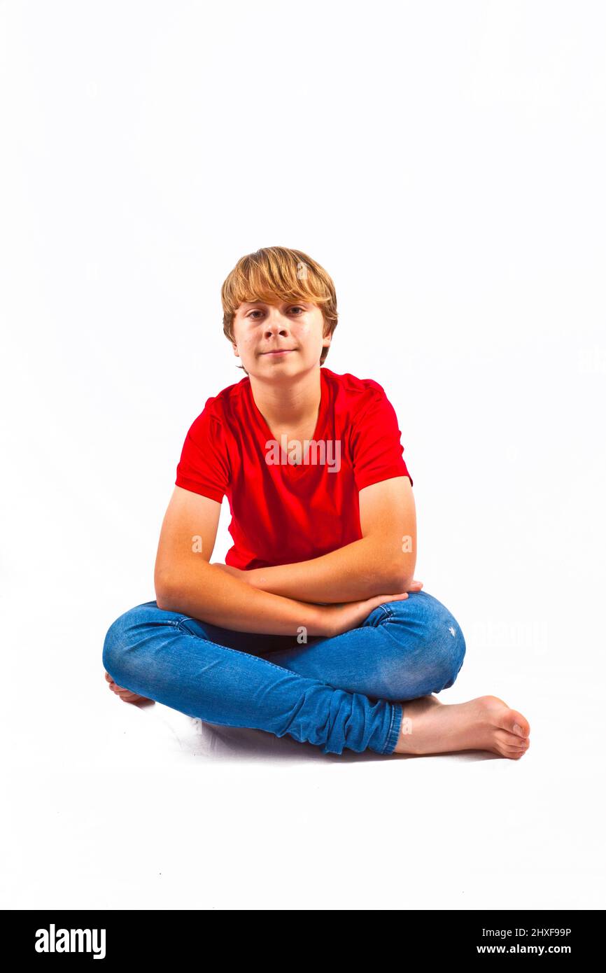 smart boy with red shirt sitting in tailor seat at the floor Stock Photo