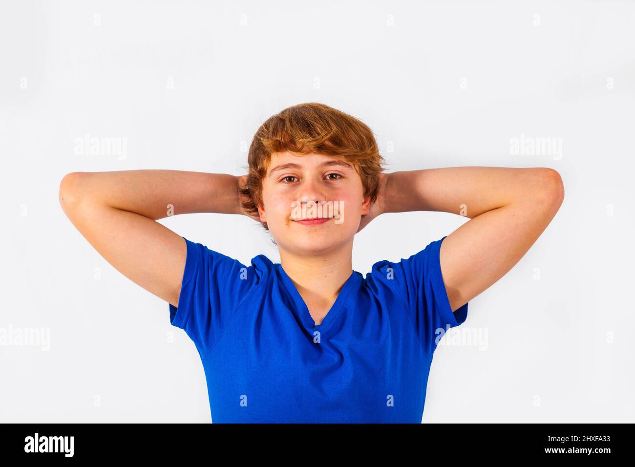 cool smiling boy keeps his arms behind his head Stock Photo