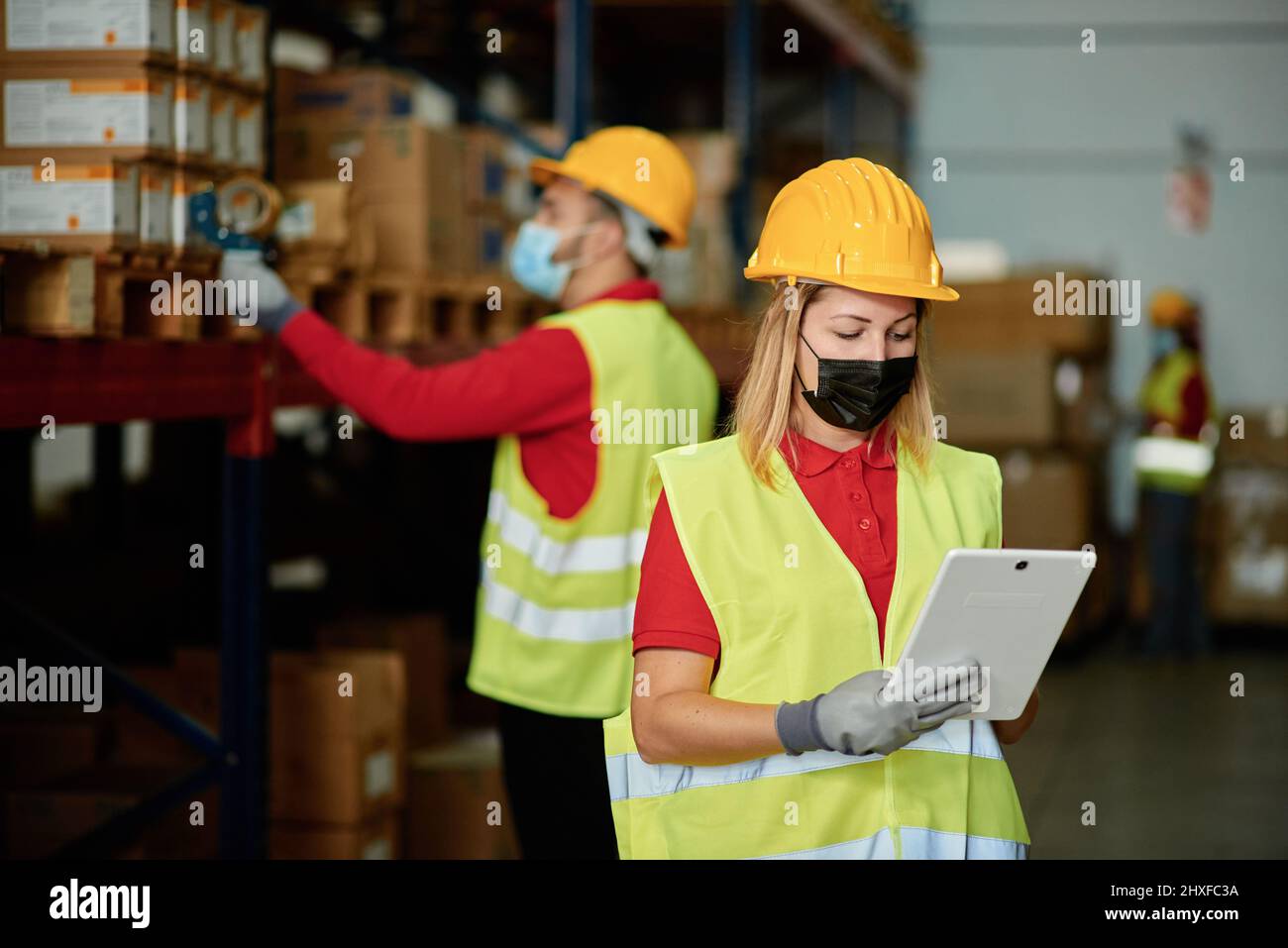 Workers in protective masks using tablet Stock Photo