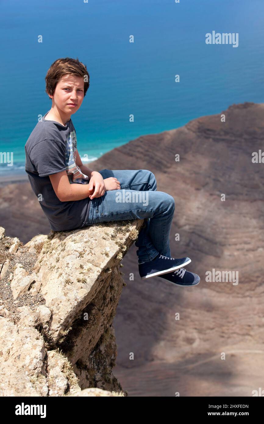 boy sitting on a rock with view to the canyon Stock Photo - Alamy