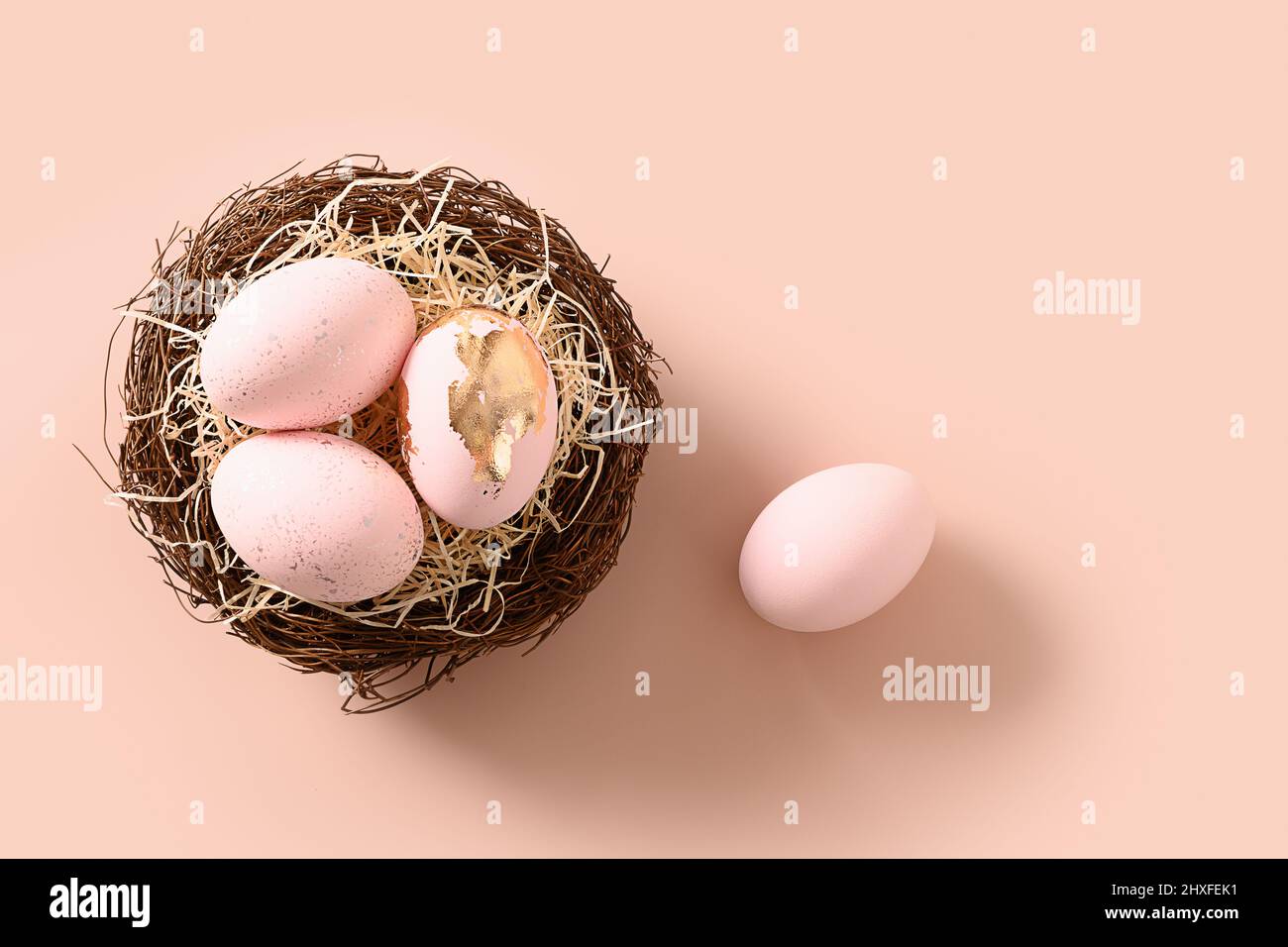 Easter pink eggs in nest on pink background. View from above. Copy space. Happy Easter greeting card with copy space. Top view. Stock Photo