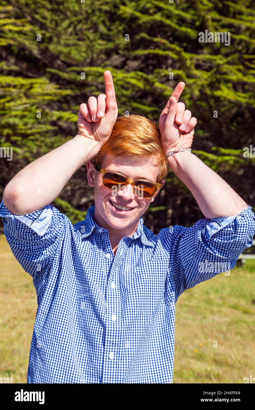 cool teenage boy with sunglasses walks happy on the meadow Stock Photo ...