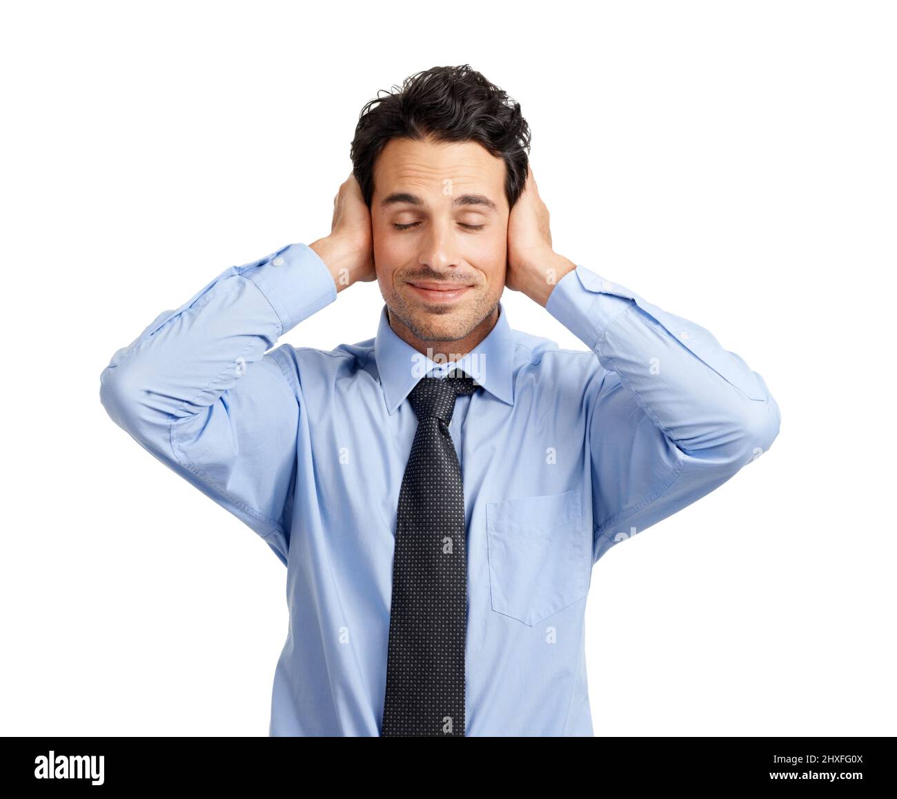 Blissfully ignorant. Studio shot of a handsome businessman covering his ears. Stock Photo