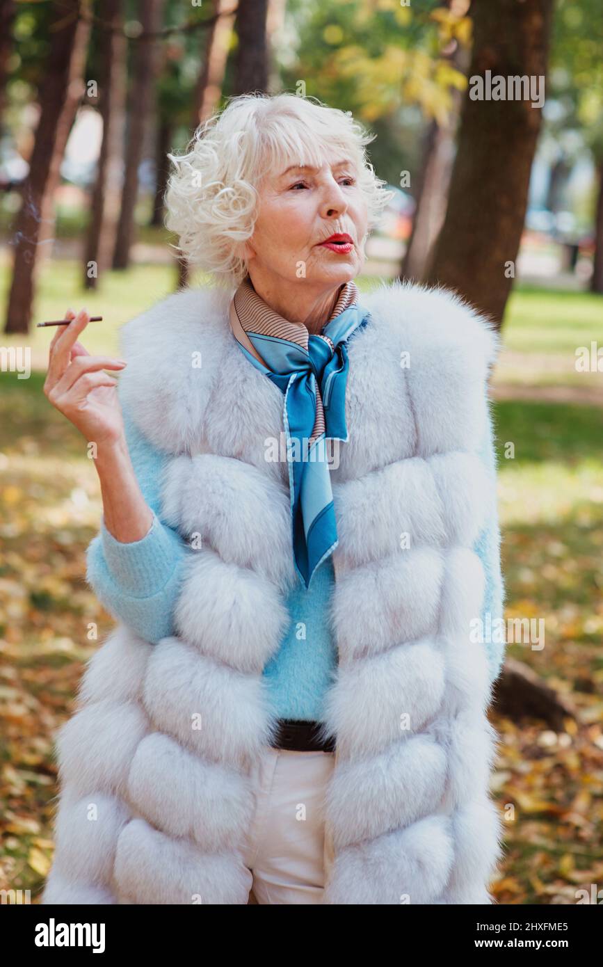 sad fashionable senior woman with grey hair in fur coat outdoor smoking  cigarette. Unhealthy lifestyle, age, oldness, addiction, bad habit concept  Stock Photo - Alamy