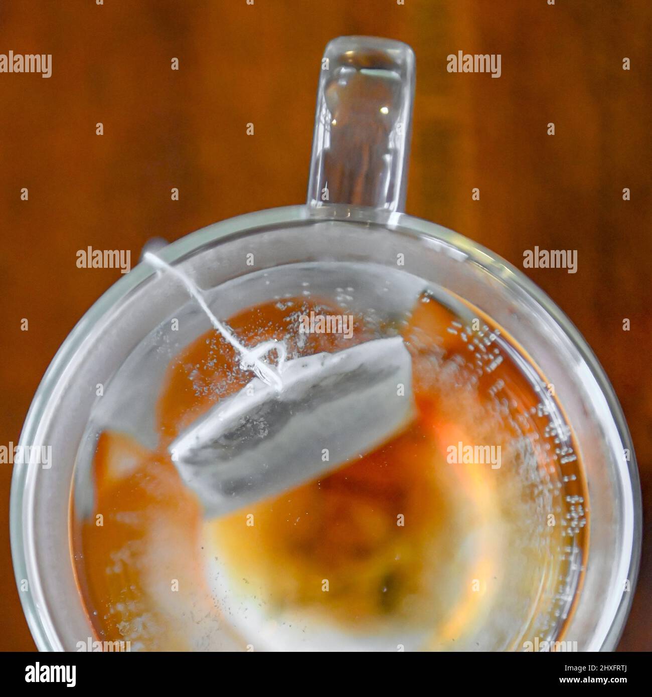 Brewing tea bag in water caffeine drink in double glass walled tea