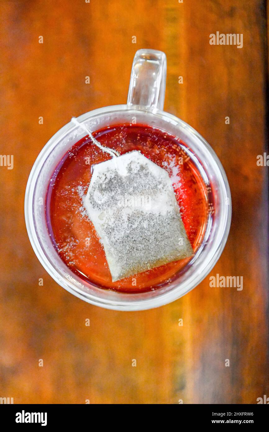 Brewing tea bag in water - caffeine drink in double glass walled tea ...