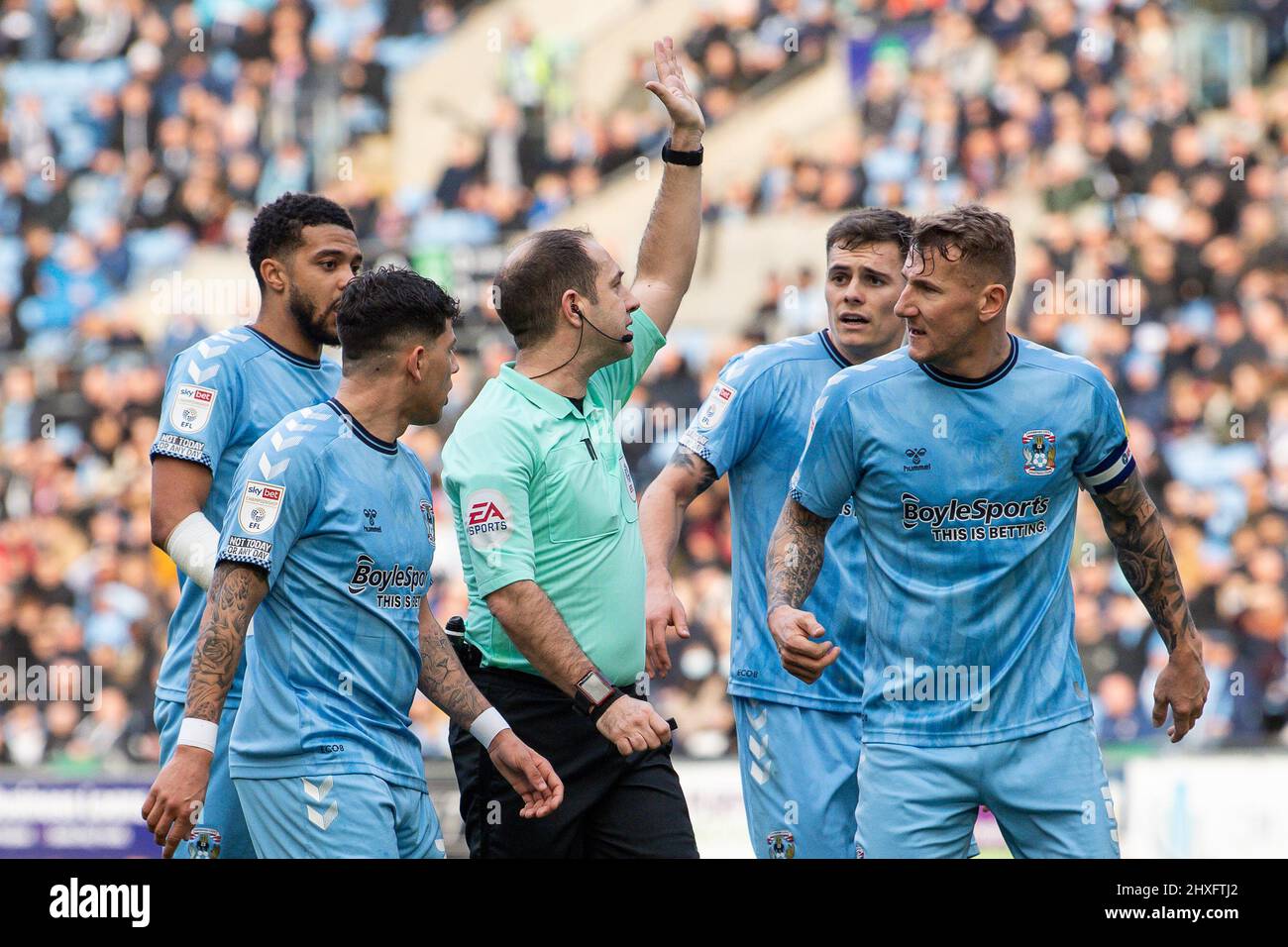 Referee Jeremy Simpson is surrounded by Coventry City players after giving a free kick inside the box for a pss back to keeper Simon Moore #1 in ,  on 3/12/2022. (Photo by Craig Thomas/News Images/Sipa USA) Stock Photo