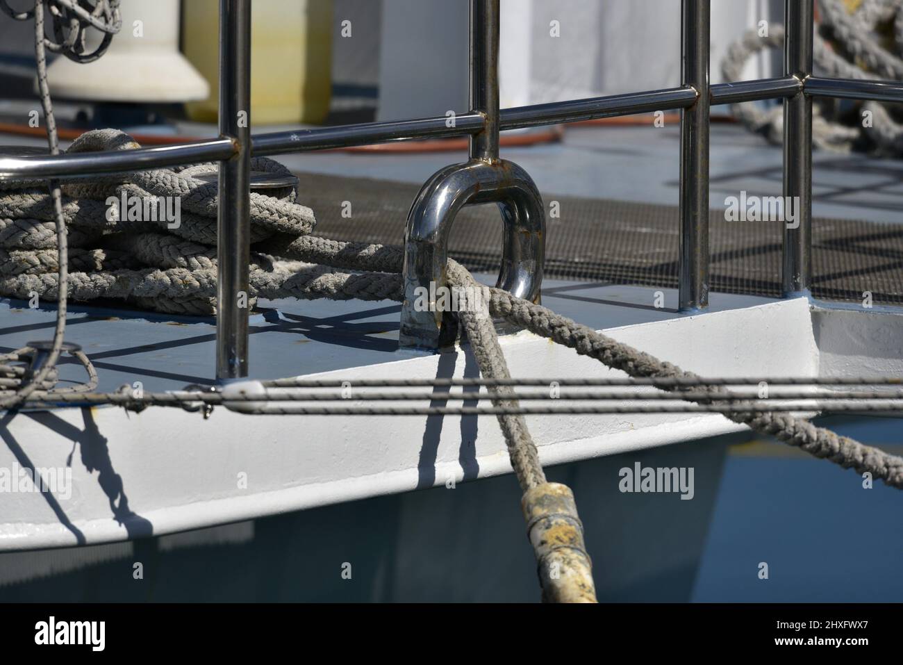 Sailing boat galvanized anchor hole and mooring rope closeup Stock