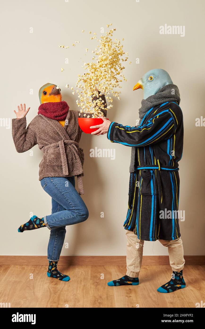 Couple dressed as birds have a surprise for popcorn in the air Stock Photo