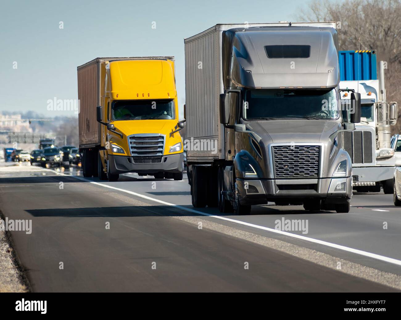 Horizontal shot of a heavy semi trucks convoy on the interstate. Stock Photo