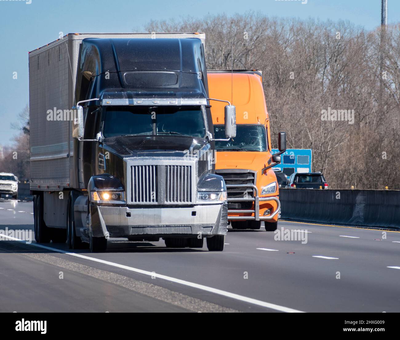 Horizontal shot of two heavy trucks on an interstate highway. Stock Photo