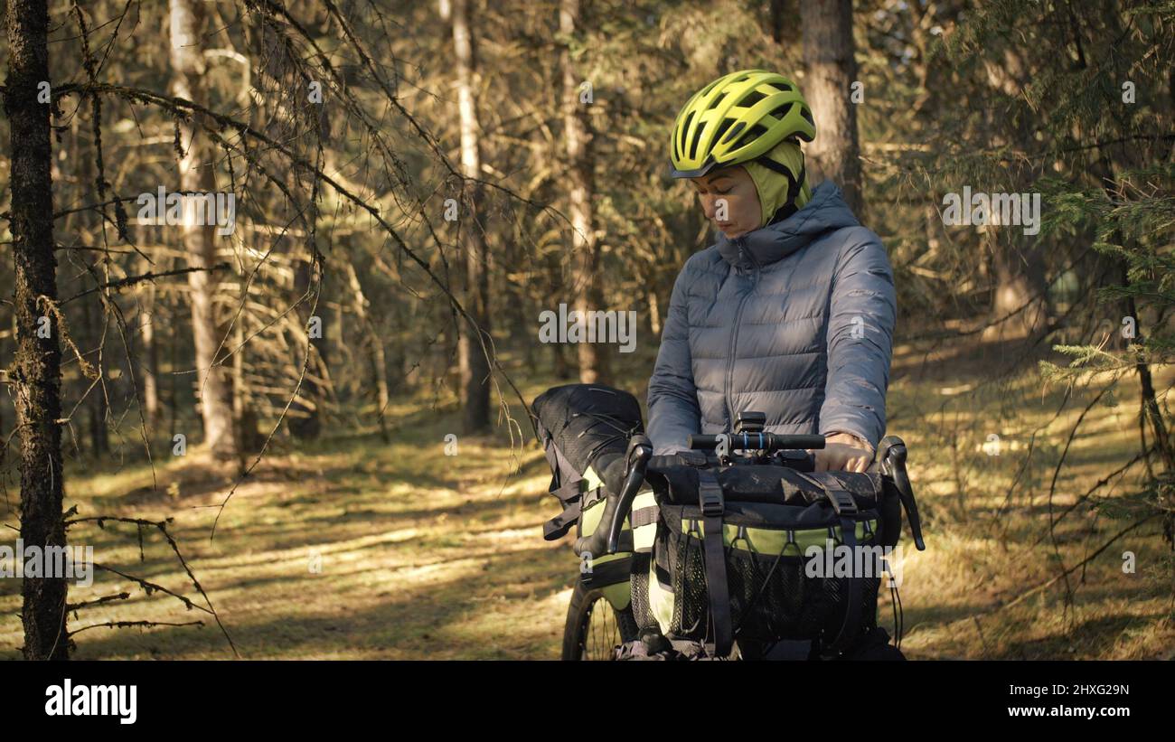 The woman travel on mixed terrain cycle touring with bike bikepacking outdoor. The traveler journey with bicycle bags. Stylish bikepacking, bike, spor Stock Photo