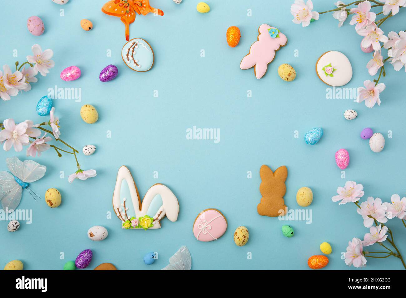 Blue Easter holiday background with eggs flowers cookies bunny Stock Photo