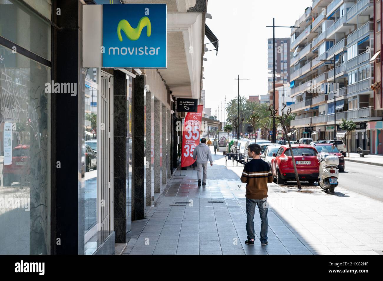 A pedestrian stands in front of the Spanish telecommunications brand owned by Telefonica and largest mobile phone operator, Movistar, store seen in Spain. Stock Photo